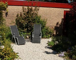 Rustige tuin met ligstoelen bij bungalow Om de Loop in Rockanje aan de Noordzeekust.