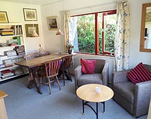 Knusse eetruimte in Om de Loop bungalow in Rockanje, Zuid-Holland, met uitzicht op de tuin.