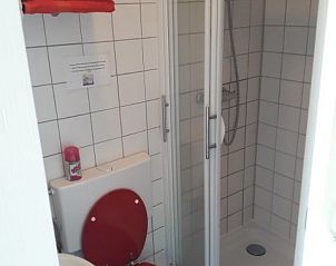 Compacte badkamer met douche in Om de Loop bungalow in Rockanje, Zuid-Holland.