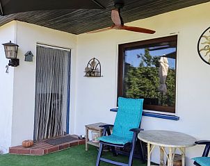 Verken de charmante veranda van Zonneheuvel in Daun, Eifel, een vakantiehuis met uitnodigende stoelen en een prachtig uitzicht op de omgeving.